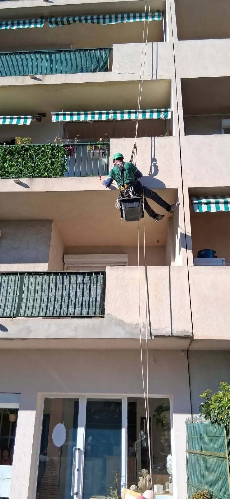 Technicien intervenant sur corde le long d'une façade